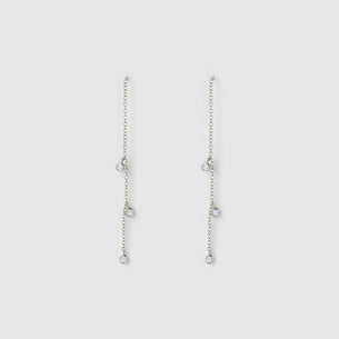 A pair of silver dangle earrings with multiple small chain drops and clear teardrop-shaped stones, shown against a light gray background.