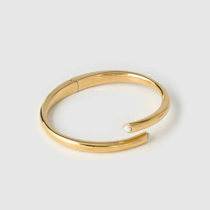 Gold bangle on a light gray background