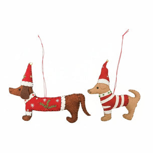 Two Christmas-themed dog ornaments with red hats and sweaters on a white background